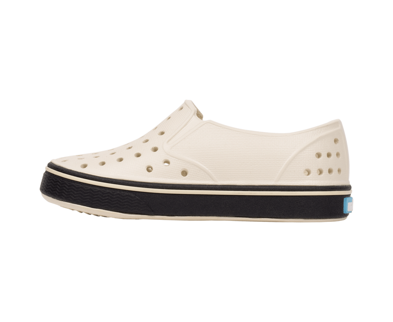 Angled view of a Native Shoes Kids Miles Kids | Bnwht/Jfyblk Footwear in Bnwht/Jfyblk